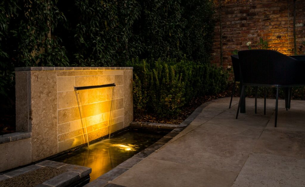 Outdoor lighting ideas showing an illuminated water feature by Cheltenham garden designers Keltie & Clark